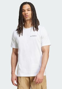 White short-sleeve t-shirt with a crew neckline, featuring a grey "TERREX" logo on the left chest. Smooth fabric, regular fit.