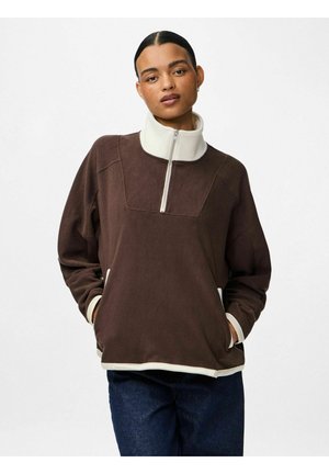 Pruun fliisist pullover kõrge valge kraega, pool-luku kinnise ja kontrastsete valgete äärtega varrukatel ja ääres. Omab mugavat lõiget.