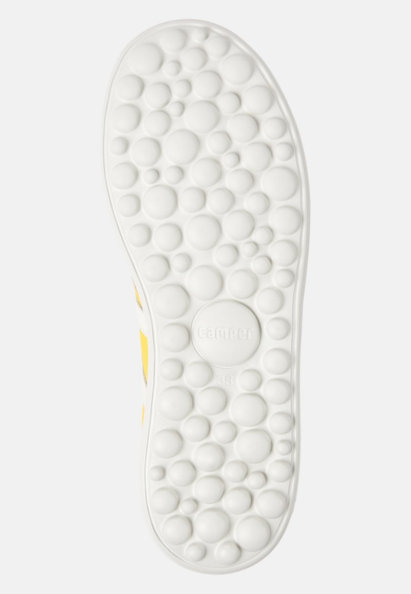 Suela de zapatilla blanca con una superficie texturizada que presenta patrones circulares elevados, con la marca "Camper" y el tamaño "38" en el centro.