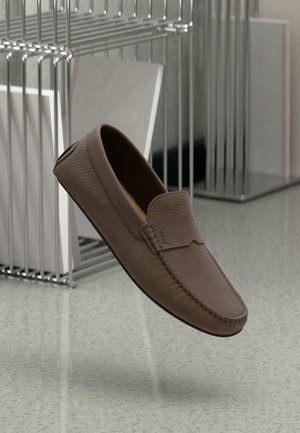Bruna läderloafers med en texturerad yta, sydda detaljer och rundad tå. Lätt vikt, flexibel sula med minimala designakcent.