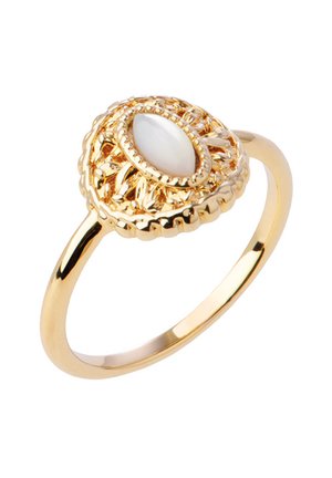 Bague en or avec un design en filigrane complexe entourant une pierre ovale blanche centrée, ressemblant à une perle.