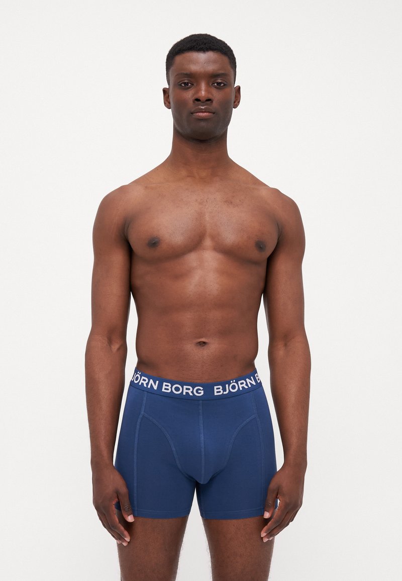 Navy blue boxer shorts made of soft cotton, featuring a thick white elastic waistband with "BJÖRN BORG" branding and a snug fit.