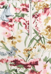 White fabric with colorful floral print in pink, yellow, green, and blue shades, featuring a vertical silver zipper at the center.
