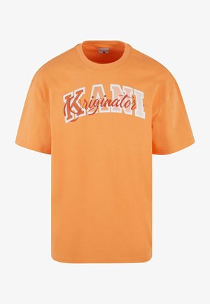 Pomarańczowa bawełniana koszulka z krótkim rękawem. Zawiera wyrazisty biały napis "KANI" oraz kursywą "Kriginator", z kontrastującymi czerwonymi akcentami. Prosty krój.