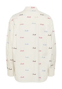 Camicia in tessuto bianco con una stampa uniforme della parola "Smile" in rosa, blu e nero in uno stile casual, scritto a mano. Collo classico e design con bottoni.