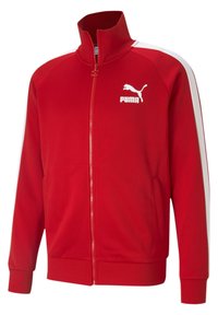 Giacca rossa con zip realizzata in un tessuto liscio, con strisce bianche sui lati e un logo Puma bianco sul lato sinistro del petto. Design con alto collo.