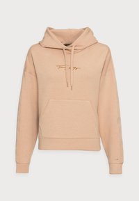 Beige kort hoodie med framfickor i kängurustil, dragsko i huvan, långa ärmar och subtil broderad logotyp på bröstet och ärmänden.