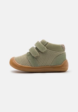 Scarpe per bambini in rete verde con due cinturini in Velcro regolabili, suola in gomma e colletto imbottito per il comfort. Finitura testurizzata sulla tomaia.