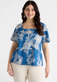 Blue short-sleeve top featuring a square neckline, white animal and botanical print, and a relaxed fit. Smooth cotton fabric.