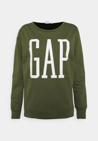 Grön bomullströja med rund halsringning och långa ärmar, med en stor vit "GAP"-logotyp framtill. Slät textur.