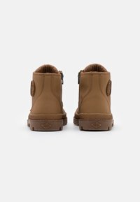 Hnědé středně vysoké boty vyrobené z hladké kůže, s zipem na každé straně a texturovanými gumovými podrážkami s logem na patě.