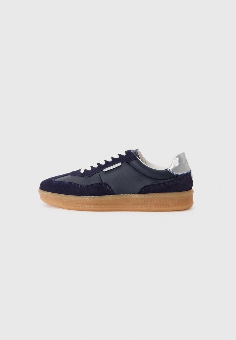 Marineblå fløjls- og lædersneaker med gummisål, hvide snørebånd og en sølvdetalje på hælen. Lav-top design med teksturerede detaljer.