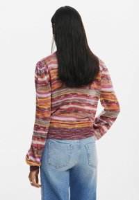 Maglione lavorato a maglia multicolore con strisce orizzontali in rosa, arancione e viola. Tessuto testurizzato con maniche a sbuffo e bordo a costine.