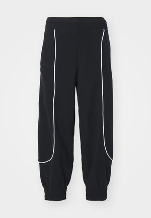 Sorte joggebukser med hvite kontrastsømmer, med elastisk liv og mansjetter ved ankler. Mykt stoff med løs passform, designet for komfort.