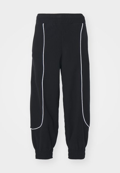 Black sweatpants with white piping, featuring an elastic waistband and cuffed ankles. Soft fabric with a loose fit, designed for comfort.