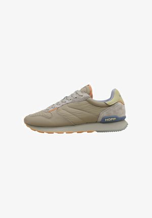 Chaussure de sport beige avec dessus synthétique texturé, accents orange, talon bleu clair et semelle grise. Présente un design à lacets et un soutien rembourré.