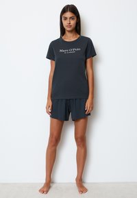 Mørkegrå bomulds-pyjamaser har en kortærmet top med hvid tekst og matchende shorts. Enkel design med en afslappet pasform og blød tekstur.