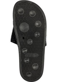 Semelle de sandale noire avec motif de bande de roulement hexagonal et prises circulaires en relief, indiquant la taille 38 EUR, 36 BRA, 7 USA.