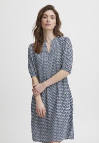 Modrá a bílá tištěná šaty s krátkými nafouklými rukávy, výstřihem do V a volným A-liniovým střihem, s geometrickým vzorem po celém povrchu.