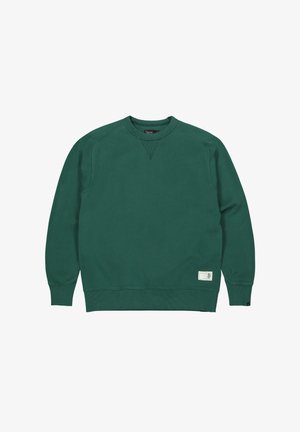 Donkergroene crewneck trui met lange mouwen, geribde manchetten en zoom, en een klein rechthoekig label nabij de onderzoom aan de voorkant.