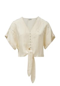 Blusa in lino beige tagliata, con maniche corte, scollatura a V, chiusura frontale con bottoni e dettaglio annodato in vita. Presenta una leggera ricamatura.