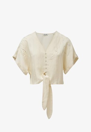 Blusa in lino beige tagliata, con maniche corte, scollatura a V, chiusura frontale con bottoni e dettaglio annodato in vita. Presenta una leggera ricamatura.