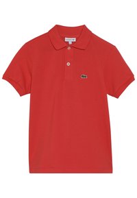Red polo shirt made of cotton with a collared neckline, three buttons, short sleeves, and a green embroidered crocodile logo on the chest.