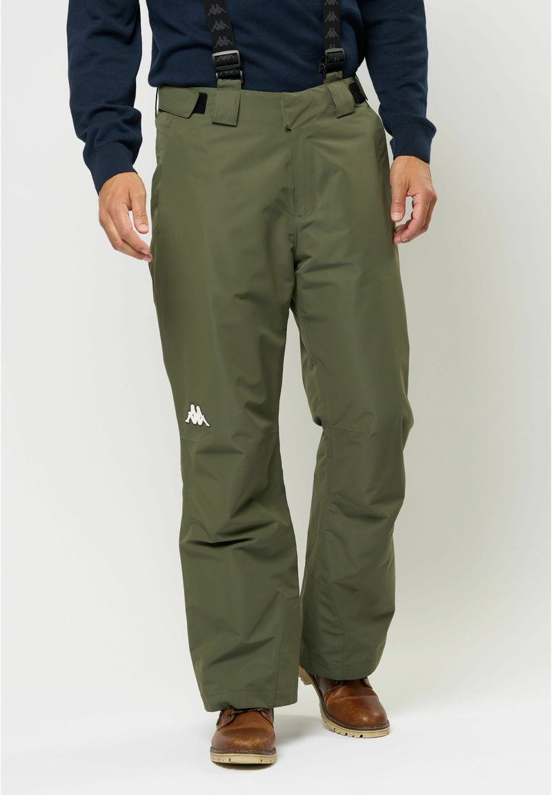 Zöld, vízálló sínadrág állítható pántokkal, fehér logóval a combon és laza szabással a kényelem és a mozgás szabadsága érdekében.