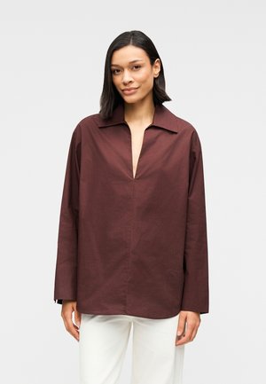 Μακρυμάνικο πουκάμισο βουργουνδί με βαθύ V-λαιμόκοψη και γιακά, κατασκευασμένο από λείο ύφασμα, με άνετη εφαρμογή και μινιμαλιστικό σχέδιο.