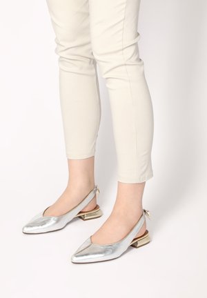 Metallic silberne Slingback-Absätze mit spitz zulaufenden Zehen, einem kleinen Blockabsatz und einer dekorativen Schleife auf der Rückseite. Glatte Textur und elegantes Design.
