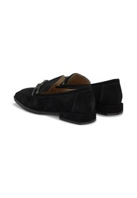 Mocasines de ante negro con tacón plano, punta redondeada y una cadena metálica decorativa sobre la parte superior.