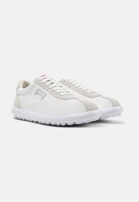 White sneakers with gray accents, featuring a smooth fabric upper, lace closure, and a textured sole for grip. Minimalist design elements.
