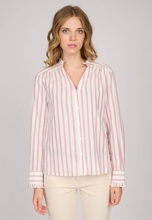 Blouse à manches longues en tissu léger, avec des rayures verticales roses et violettes, un col volanté et une fermeture à boutons. Accents crème aux poignets.
