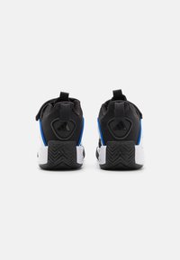 Scarpe sportive in bianco e nero con accenti blu, tomaia in rete, collo imbottito e suola in gomma con motivo a spina di pesce.
