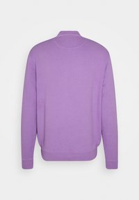 Fioletowa bluza z okrągłym dekoltem, ściągaczami przy mankietach i u dołu. Gładki materiał, prosty design, bez widocznych logo ani wzorów.