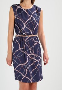 Vestido azul marino con un patrón de cadenas en rosa y blanco. Diseño sin mangas, cintura ajustada con cinturón y tela suave con un caíd suave.