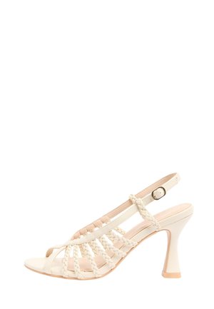 Sandale à talon couleur crème avec brides tressées, design slingback et boucle réglable sur un talon haut évasé.