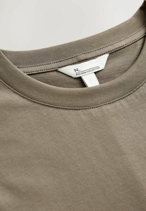 Olivgrön bomulls-T-shirt med rund krage, synlig sömdekoration ochetikett som säger "N. PREMIUM COLLECTION." Slät textur.