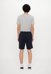 Gray short-sleeve t-shirt paired with navy shorts, featuring an elastic waistband and casual fit. A plain design with minimal detailing.