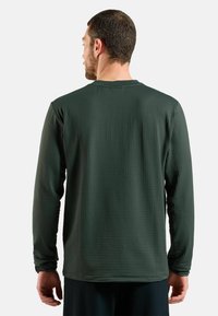 Langärmeliges, dunkelgrünes Sportshirt mit strukturiertem Muster, Rundhalsausschnitt und taillierten Manschetten, von hinten präsentiert.