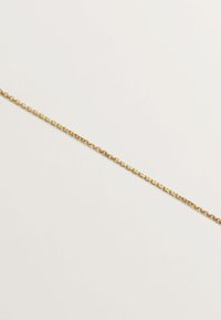 Collar de cadena dorada con eslabones ovalados, textura suave y un diseño minimalista, colocado plano sobre un fondo neutro.