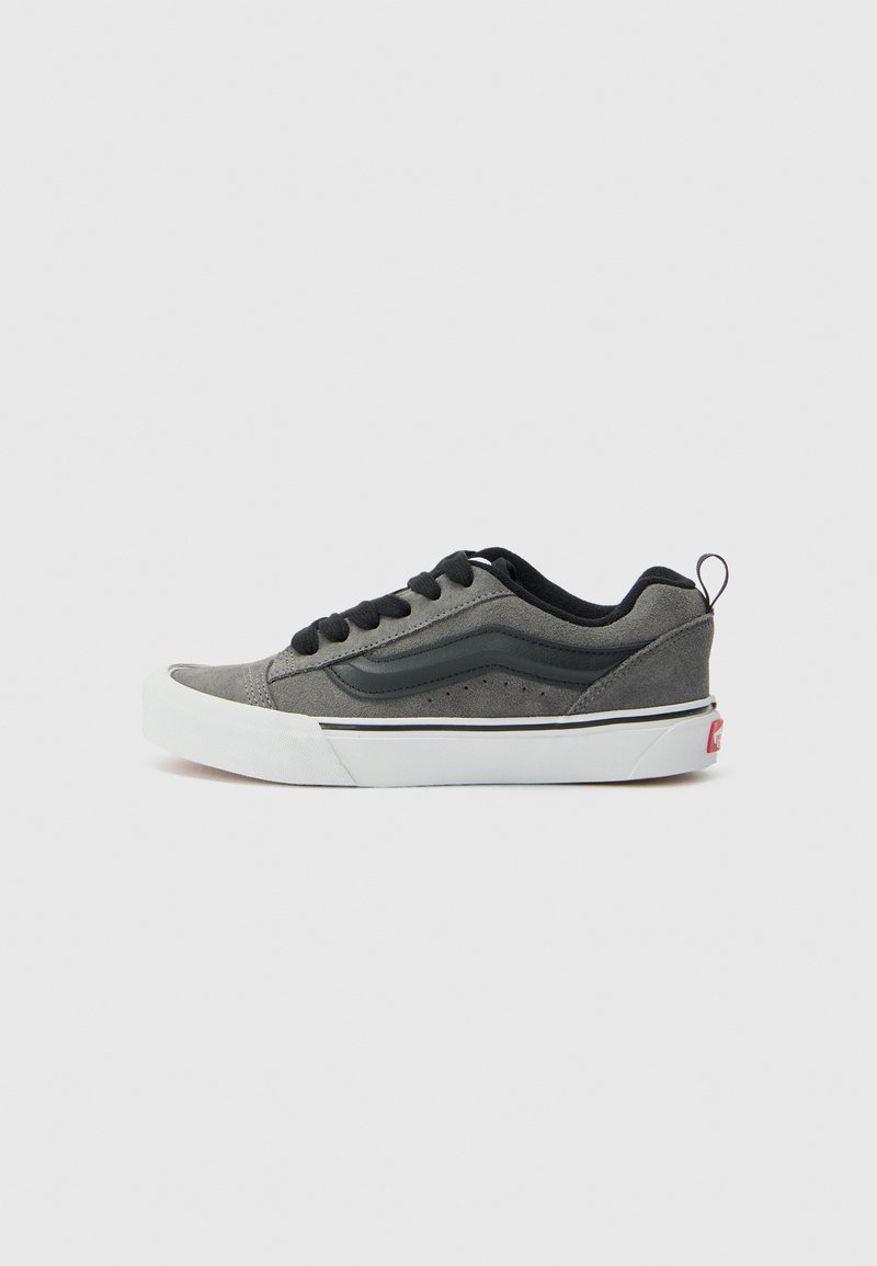 Baskets en daim gris avec des accents noirs, lacets plats, semelle en caoutchouc blanche et bande latérale signature. Bout arrondi et petite languette au talon.