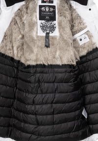 Black puffer jacket with a faux fur collar. Inside features a smooth black lining, quilted pattern, and a tag labeled "NAVAHOO PREMIUM 2014."