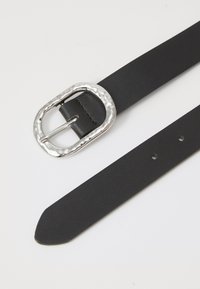 Curea din piele neagră cu o cataramă texturată din argint. Catarama are un design ciocănit, iar curea include cinci găuri de ajustare.