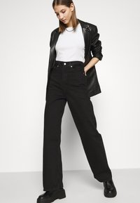 Levi's® HIGH LOOSE - Calças de ganga à boca de sino - black denim
