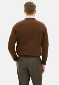 Maglione marrone a maglia con orlo e polsini a coste, abbinato a pantaloni grigi con texture. La vista dal retro mostra una silhouette dritta.