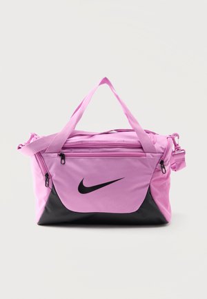 Ružová a čierna športová taška Nike s viacerými vreckami so zipsom a dvojitými rukoväťami, na jednoduchom svetlom pozadí.