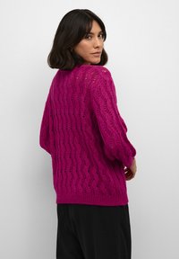 Maglione lavorato a maglia in fucsia brillante con un motivo ondulato, texture a trama aperta e maniche a tre quarti, con orlo a costine.