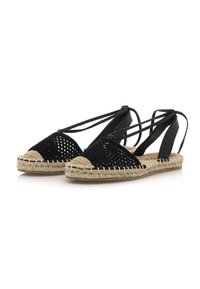 Espadrilles tissées noires avec une semelle en jute, présentant un bout pointu, des sangles réglables et un dessus en maille texturée.