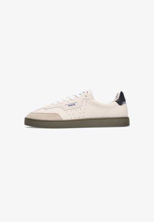 Sneaker with a cream leather upper, grey suede toe cap, perforated side detail, white laces, and a dark green rubber sole.
